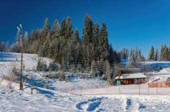 Thrilling Epic Christmas 2025 Murzasichle Tatra Adventures: Frosted pines frame a snowy ski slope with a cosy wooden hut, blue skies, and distant peaks in Poland's winter paradise. Frosted pines frame a snowy ski slope with a cosy wooden hut
